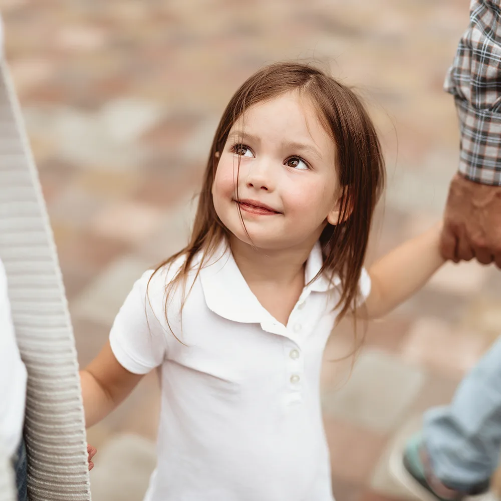 Child smiling up at mom at a Little Sprouts daycare.