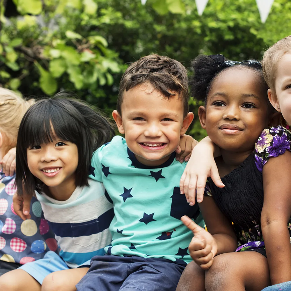 A group of children smiling outside of a Little Sprouts daycare