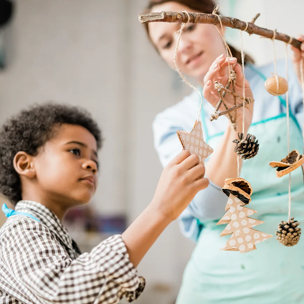 A child looking at stars hanging on string from a branch in a Little Sprouts daycare