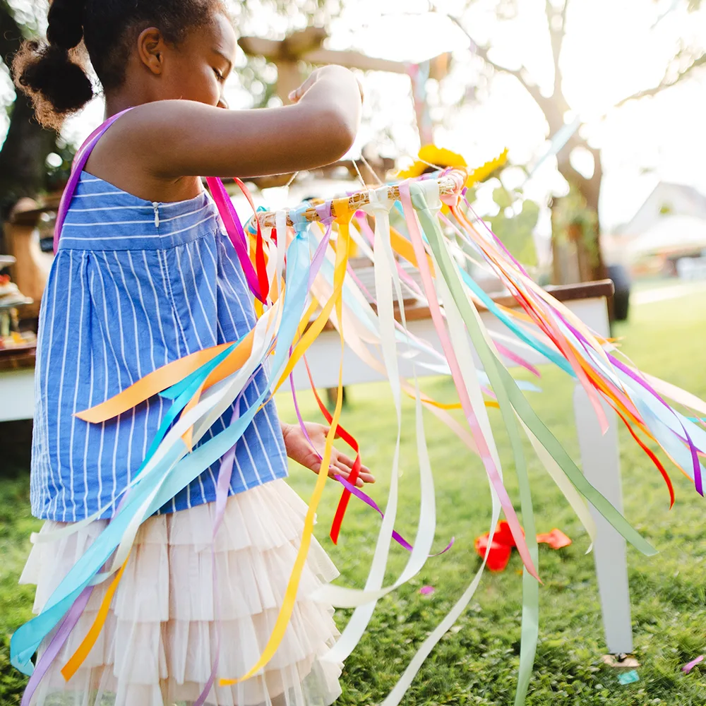 A child working on a colorful summer craft outside of a Little Sprouts daycare