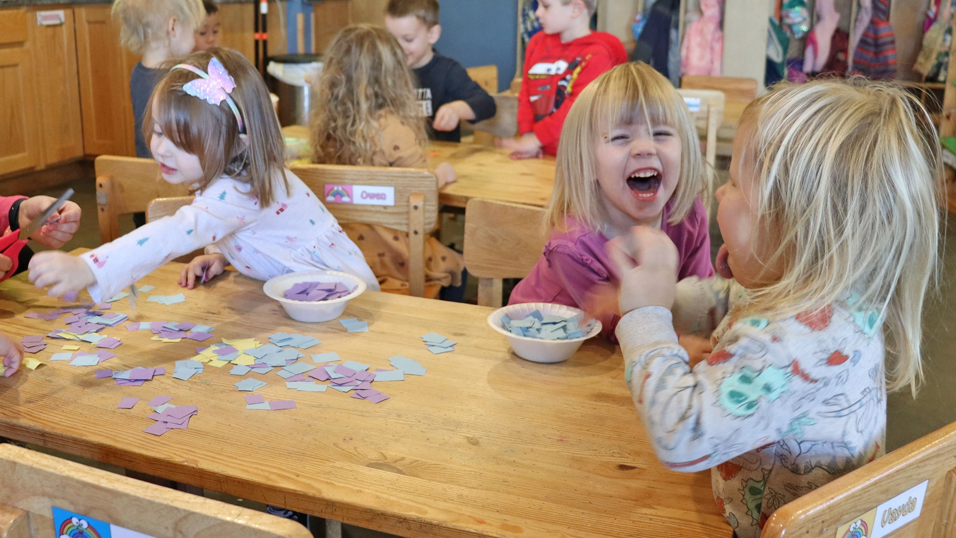 Children laughing and playing at a table at a Little Sprouts daycare