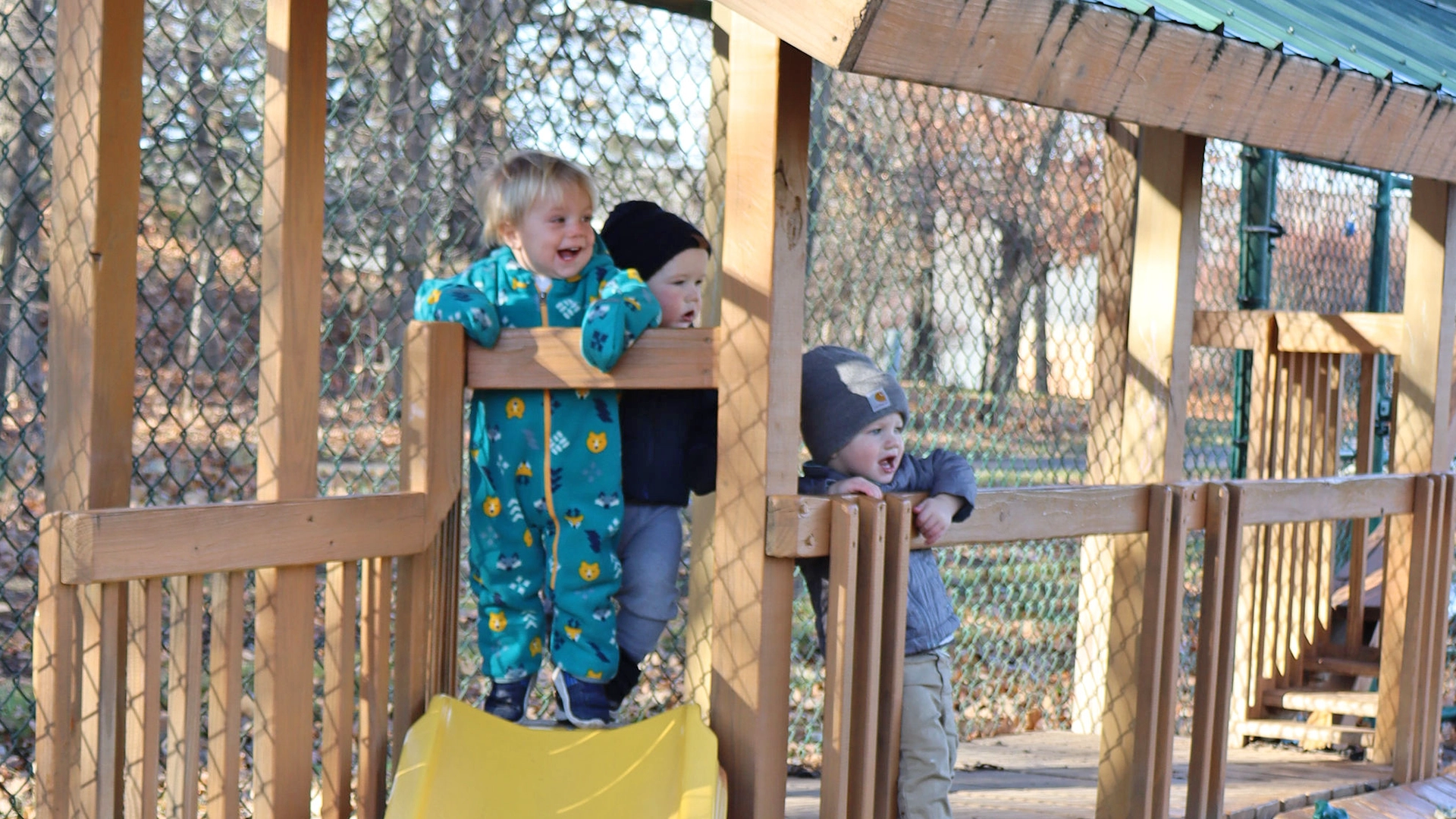 Children lined up to go down a slide outside of a Little Sprouts daycare