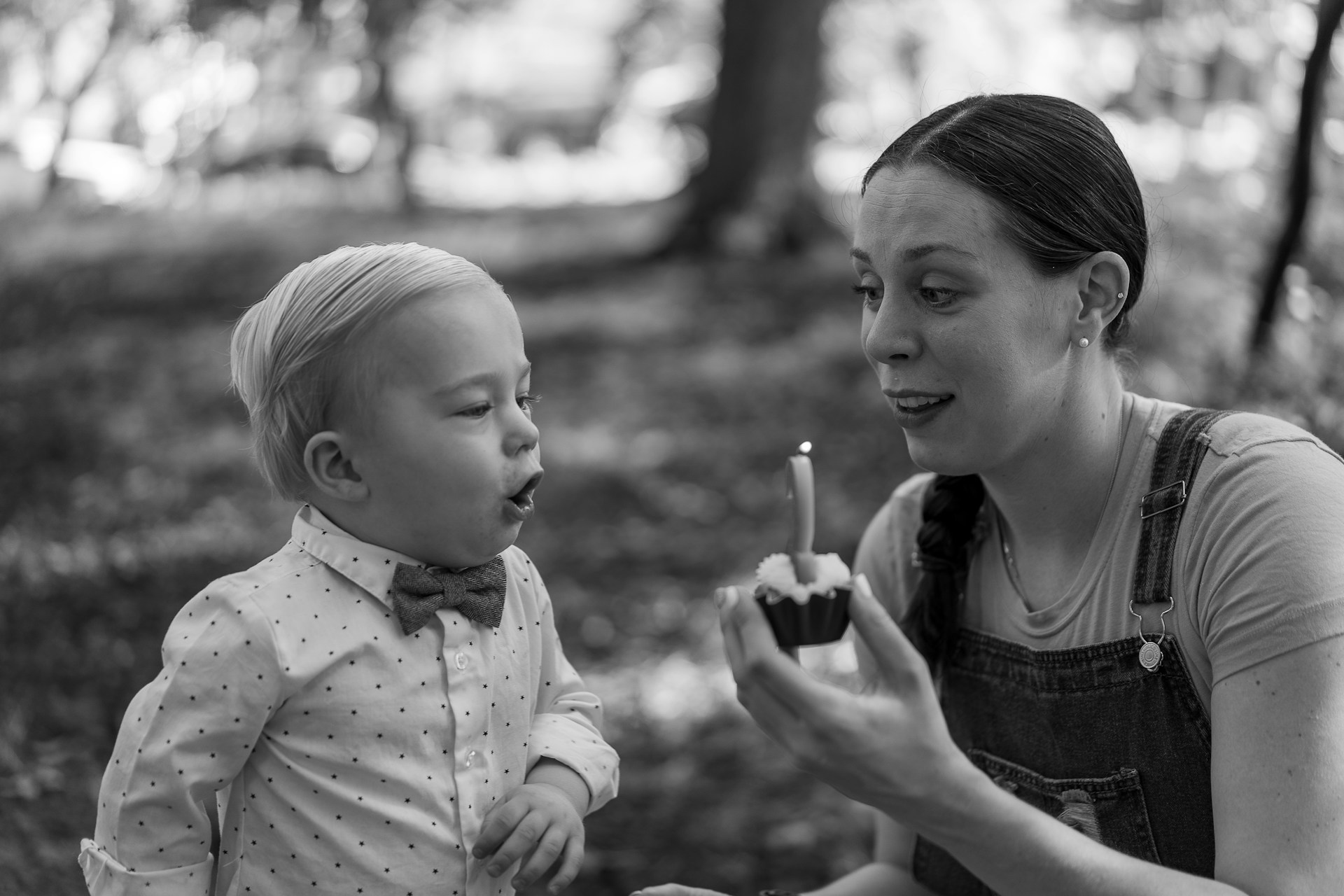 Toddler on their birthday with a cupcake and candle to blow out