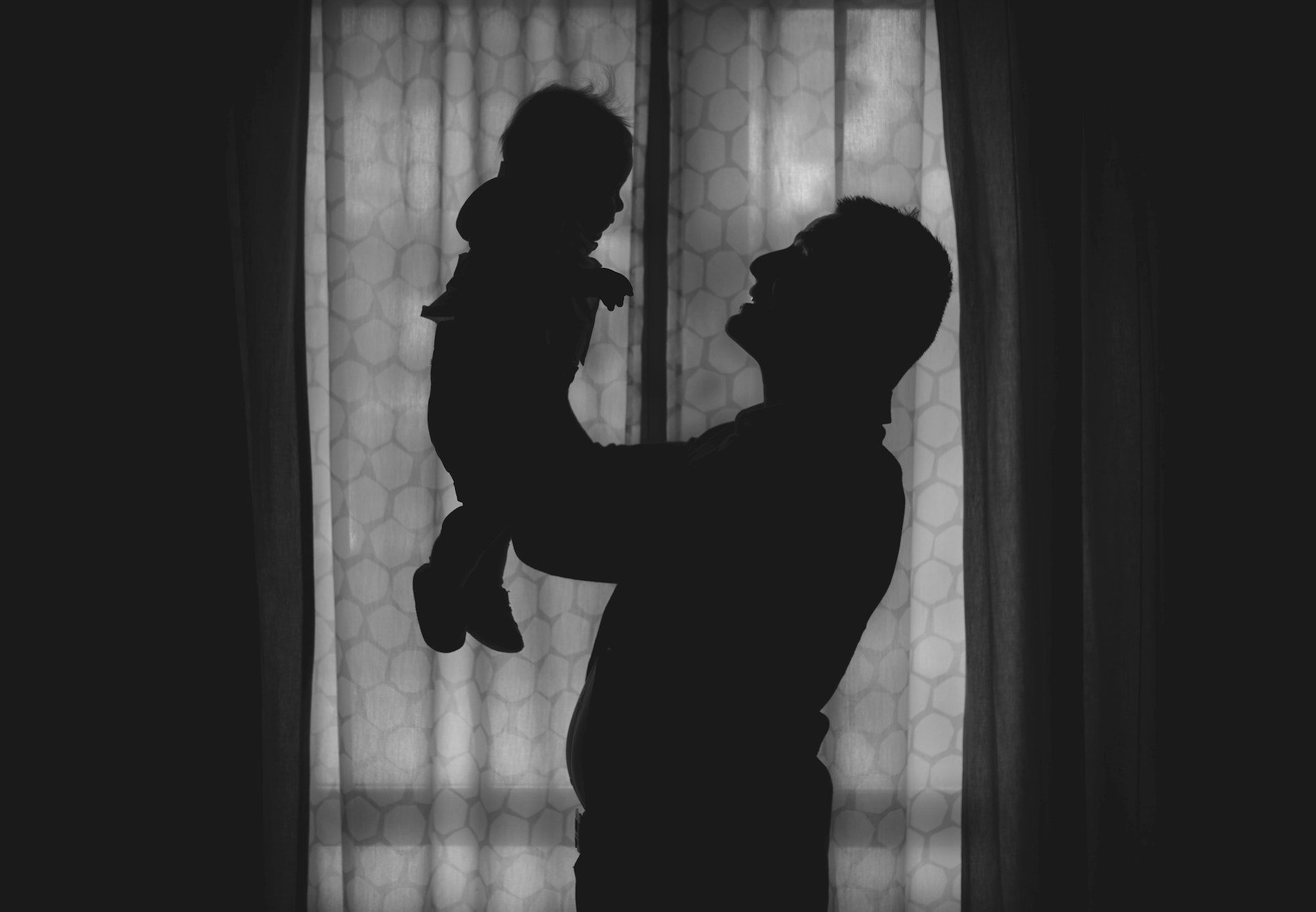 Silhouette of father holding child