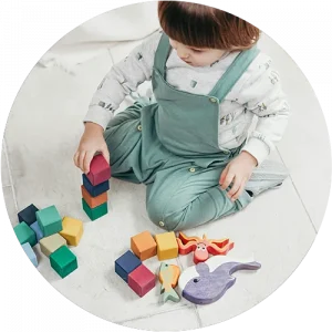A child playing with blocks on the floor at a Little Sprouts daycare